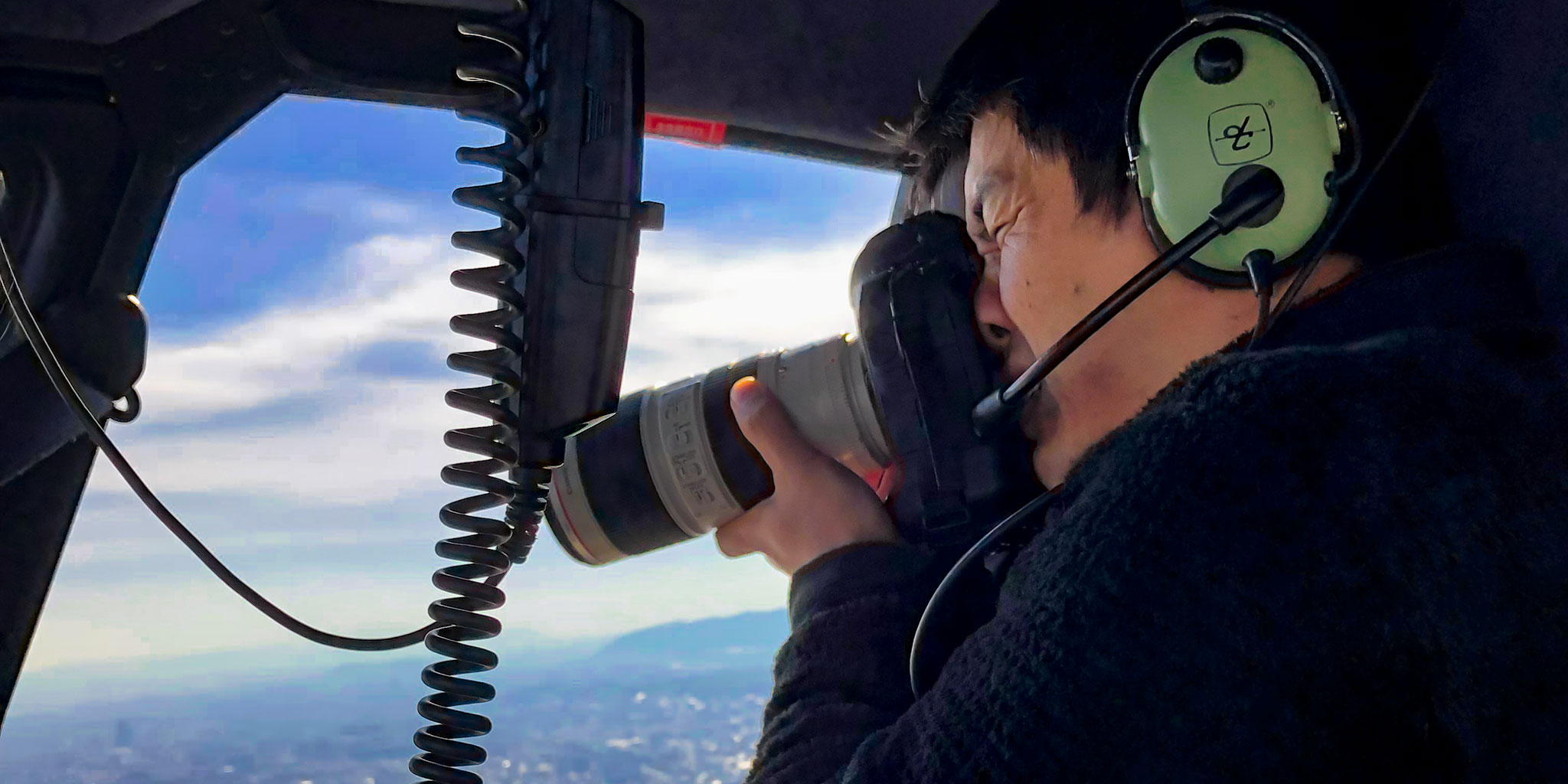 ヘリコプター空撮をするカメラマン